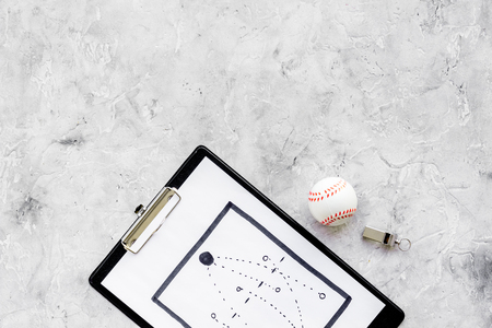 Sport coach concept. Pad with tactic plan of the match near whistle and base-ball ball on stone background top view copy spaceの写真素材