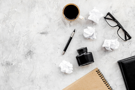 notebook, ink, dip pen, coffee, glasses for writer workplace set on stone office background top view mock-upの写真素材