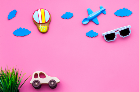 Airplan, car and air balloon toys for family traveling with child on pink background top view mock-upの写真素材