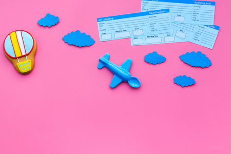 Sample of airplane ticket. Family trip with kid. Airplan, air balloon toys. Pink background flat lay space for textの写真素材