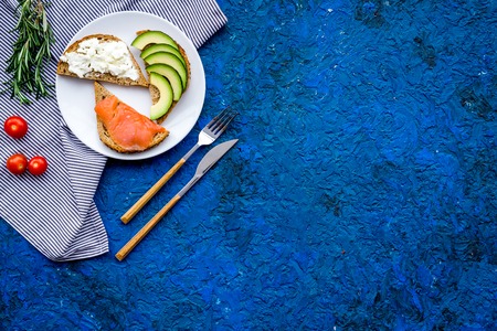 Healthy lunch with mini sandwiches cheese, fish and avocado on blue background top view space for textの写真素材