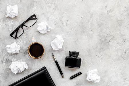 Retro and modern writer desktop with glasses, notebook and ink on stone table background top view mock upの写真素材