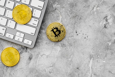 Bitcoin on keyboard for online payment on gray table background top view space for textの写真素材