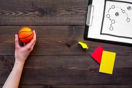 Sport judging concept. Basketball referee. Tactic plan for game, basketball ball, red and yellow cards, whistle on wooden background top view,の写真素材