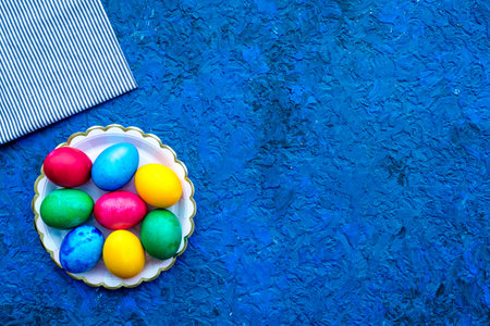 Easter celebration with colorful eggs. Blue desk background top view mock up