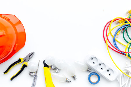 Electrician work concept. Hard hat, tools, cabel, socket outlet on white background top view space...