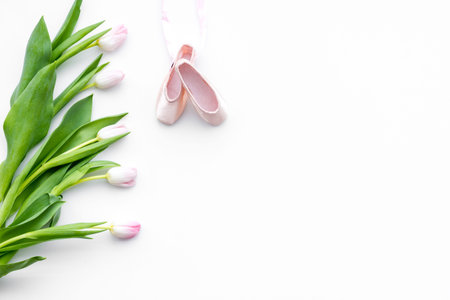 Ballet shoes near delicate flowers on white background top view copy spaceの写真素材