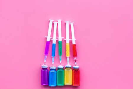 Vaccination, immunization. Syringe and bottle with medicament on pink background top view.の写真素材