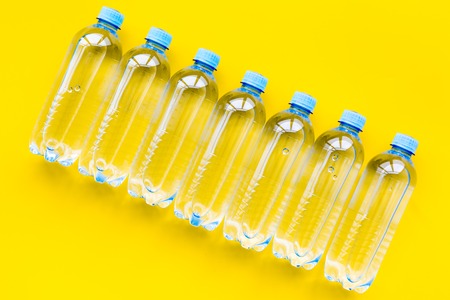 Plastic bottles with pure water on yellow background top viewの写真素材