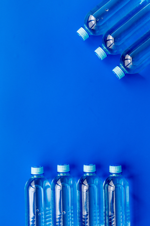 Drinking water in bottles on blue background top view.の写真素材