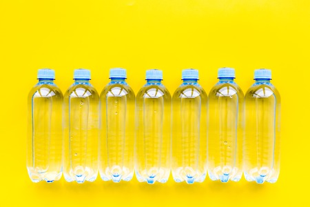 Plastic bottles with pure water on yellow background top view.の写真素材