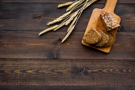 Fresh homemade bread on dark wooden background top view copy space