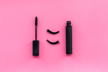 Basic products for eyelashes makeup. Mascara and false eyelashes on pink background top view.の写真素材