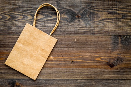 Brown kraft paper bag for shopping on wooden background top view.の写真素材