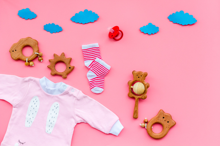Baby shower concept. Babys clothes and toys on pink background top view copy spaceの写真素材