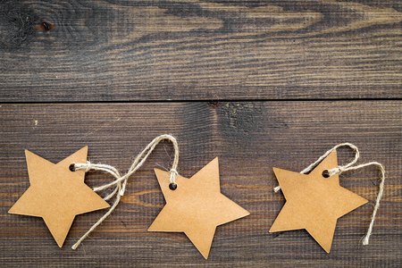 Figured blank tags for write price or discount on dark wooden background space for text mockupの写真素材