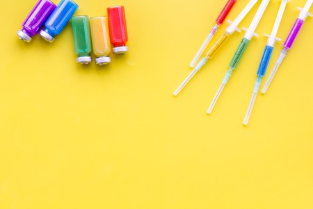 Medical injection Syringe and bottle with remedy on yellow background top view copy spaceの写真素材