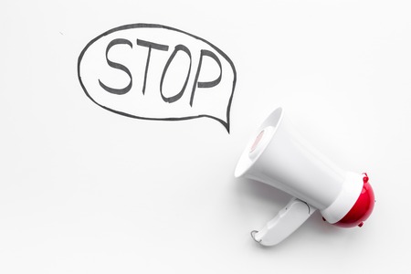 Demand to stop concept. Megaphone near cloud with word stop on white background top view.の写真素材