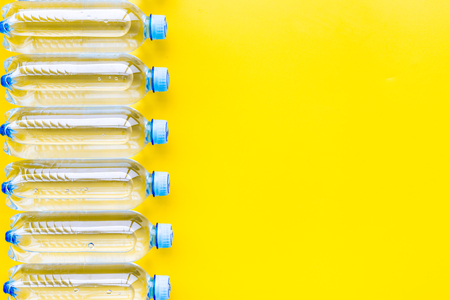 Plastic bottles with pure water on yellow background top view.の写真素材