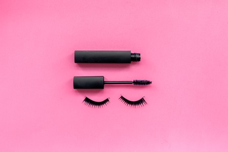 Basic products for eyelashes makeup. Mascara and false eyelashes on pink background top view copy spaceの写真素材