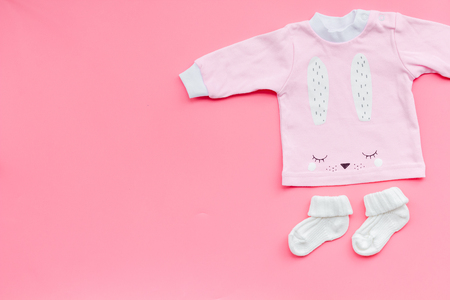 Newborn baby's background. Clothes for small girl with booties on pink background top view.の写真素材