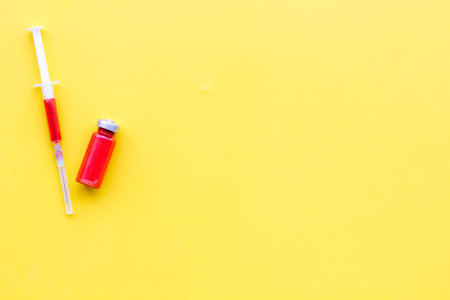 Medical injection Syringe and bottle with remedy on yellow background top view.の写真素材
