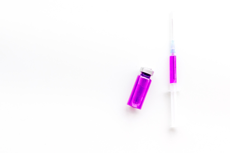 Syringe with colored drug. Injection concept on white background top view copy spaceの写真素材