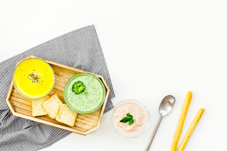 Healthy vegetarian meal. Cream soup concept. Soups with pumpkin, broccoli, mushrooms on white...