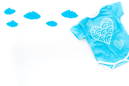 Newborn baby's sleep concept. To put the child to bed. Baby bodysuit near clouds on white background top view.の写真素材