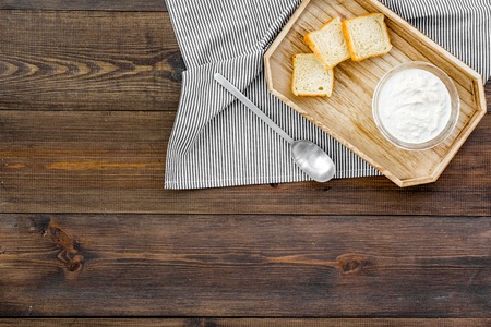 Healthy meal. White mushroom cream soup served with rusks on dark wooden background top view.の写真素材