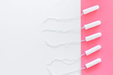 Woman hygiene protection. Cotton tampons on pink background top view copy spaceの写真素材