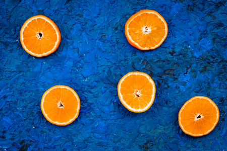 Oranges round slices pattern on blue background top view.の写真素材