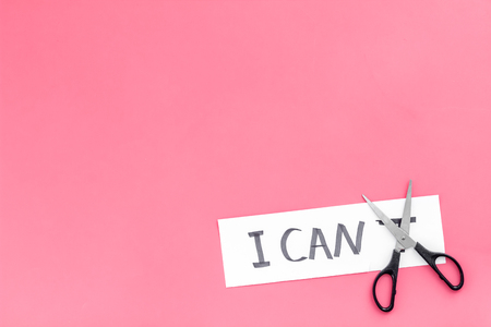 I can concept. Motivate yourself, believe in yourself. Scissor cut the letter 't' of written word I can't. Pink background top view.の写真素材