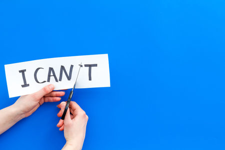 I can concept. Motivate yourself, believe in yourself. Hand cut off the letter 't' of written word I...