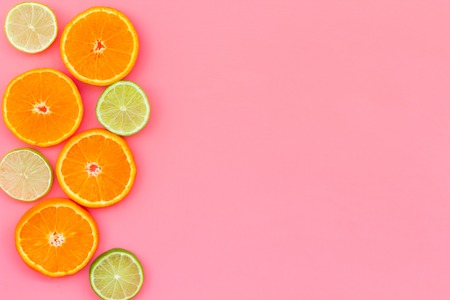 Citrus frame. Oranges and lime round slices composition on pink background top view copy spaceの写真素材