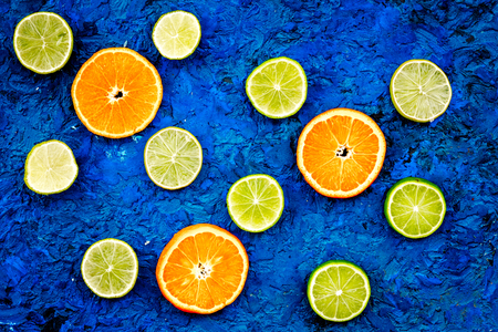 Fruit pattern. Oranges and lime round slices composition on blue background top viewの写真素材