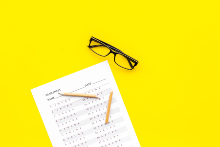 Exam sheet on yellow table top view copy space. Education concept. Exam problems. Broken pencil near exam sheet.の写真素材