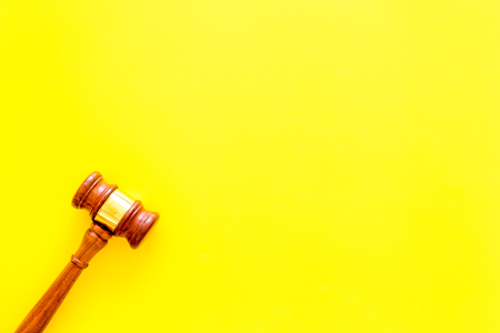 Lawyer or attorney concept. Judge gavel on yellow background top view copy space