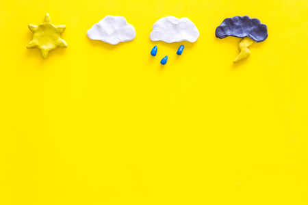 Weather forecast concept. Modern weather icons set on yellow background top view copy spaceの写真素材