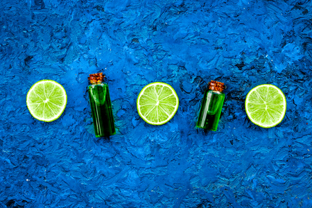 Citrus oil with lemon or lime for aromatherapy or skin care on blue background top view.の写真素材