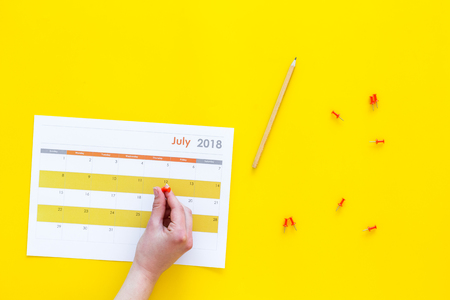 Planning. Point the date in calendar by pushpin. Set the goal. Choose date. Calendar yellow background top view copy spaceの写真素材
