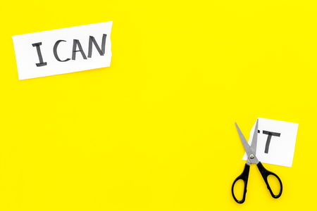 I can concept. Encourage yourself. Scissors cut off the letter t of written word I cant. Yellow background top view copy spaceの写真素材