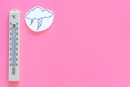 Storm weather concept. Air temperature. Cloud and lightening near thermometer on pink background top view copy spaceの写真素材