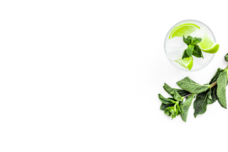 Refreshing mojito cocktail. Slices of lime, mint, glass with ice cubes on white background top view space for textの写真素材