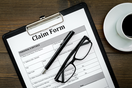 Claim form to fill out on dark wooden desk top view closeupの写真素材