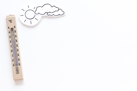 Clear and cloudy weather concept. Air temperature. Thermometer near sun on white background top view copy spaceの写真素材