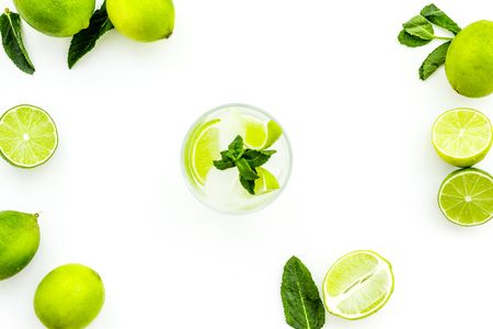 Refreshing mojito cocktail. Slices of lime, mint, glass with ice cubes on white background top view space for textの写真素材