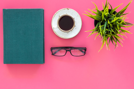 Reading for study and work. Self-education concept. business literature. Books with empty cover near glasses, coffee, plant on pink desk top view copy spaceの写真素材
