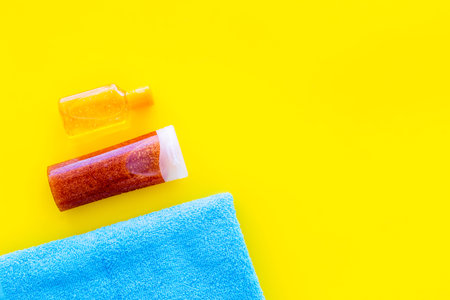 Sunscreen for sea vacation. Bottles with cream or lotion near towel on yellow background top view.の写真素材