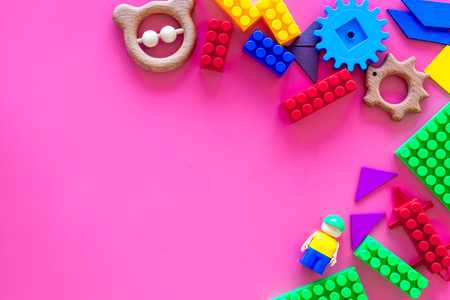 Toys for little children. Plastic bricks and clacks on pink background top view.の写真素材